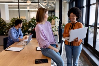 2 businesswomen discuss the benefits of an inbound marketing software on a laptop